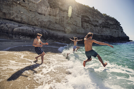 La gioia di tuffarsi al mare di tre giovani foto iStock.