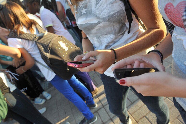 Studenti con telefoni cellulari. Immagine d 'archivio - RIPRODUZIONE RISERVATA