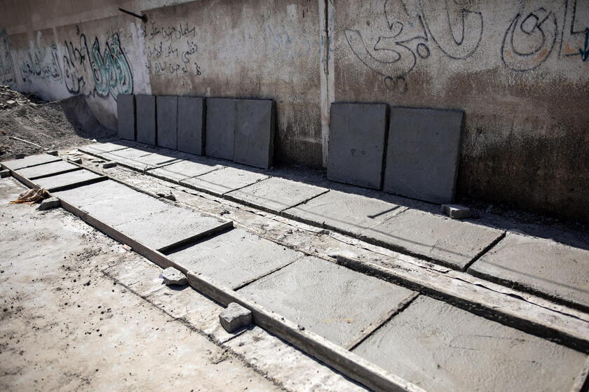 Palestinians make graves from the rubble of Gaza's destroyed homes